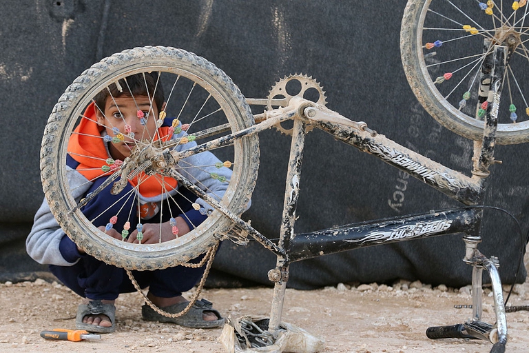 bambino siriano rifugiato bici