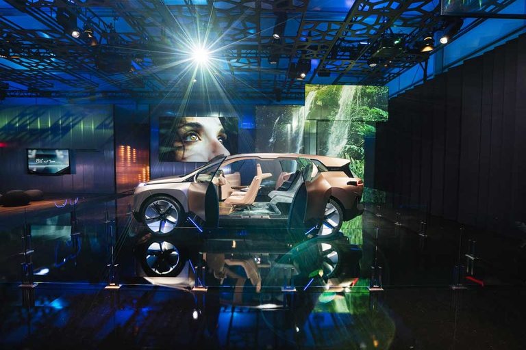 BMW iNEXT, grazie alle due porte con apertura ad armadio e all’assenza del montante centrale rende agile l’ingresso a bordo. Un'ulteriore caratteristica è l’inusuale separazione tra la plancia e la parte posteriore dell’abitacolo. Gli innovativi sedili posteriori donano all’ambiente un aspetto simile a quello di un vero e proprio salotto. A bordo, un assistente personale aiuta a pianificare spostamenti e impegni nella giornata. ©BMW