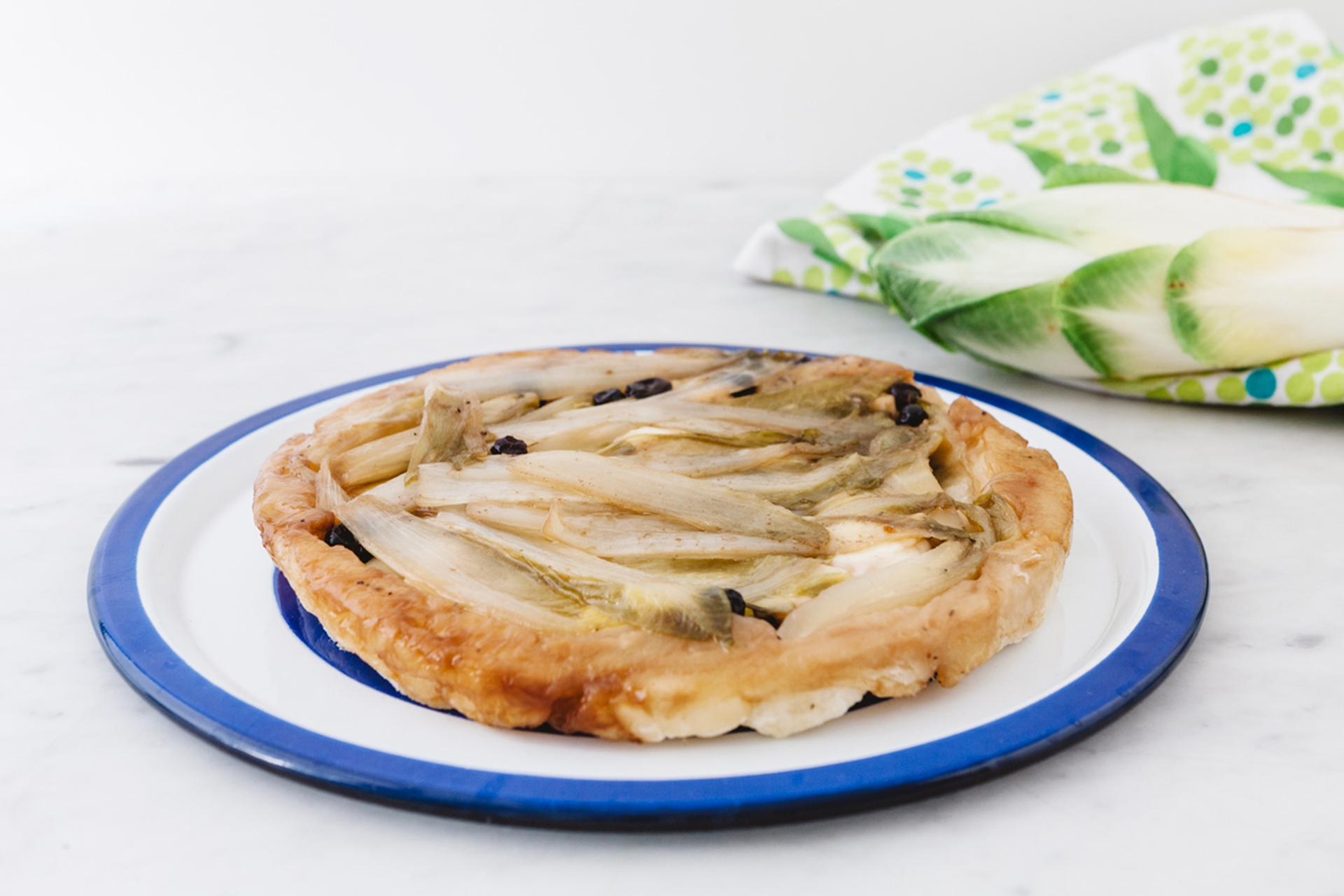 Tarte tatin con insalata belga, taleggio e mirtilli