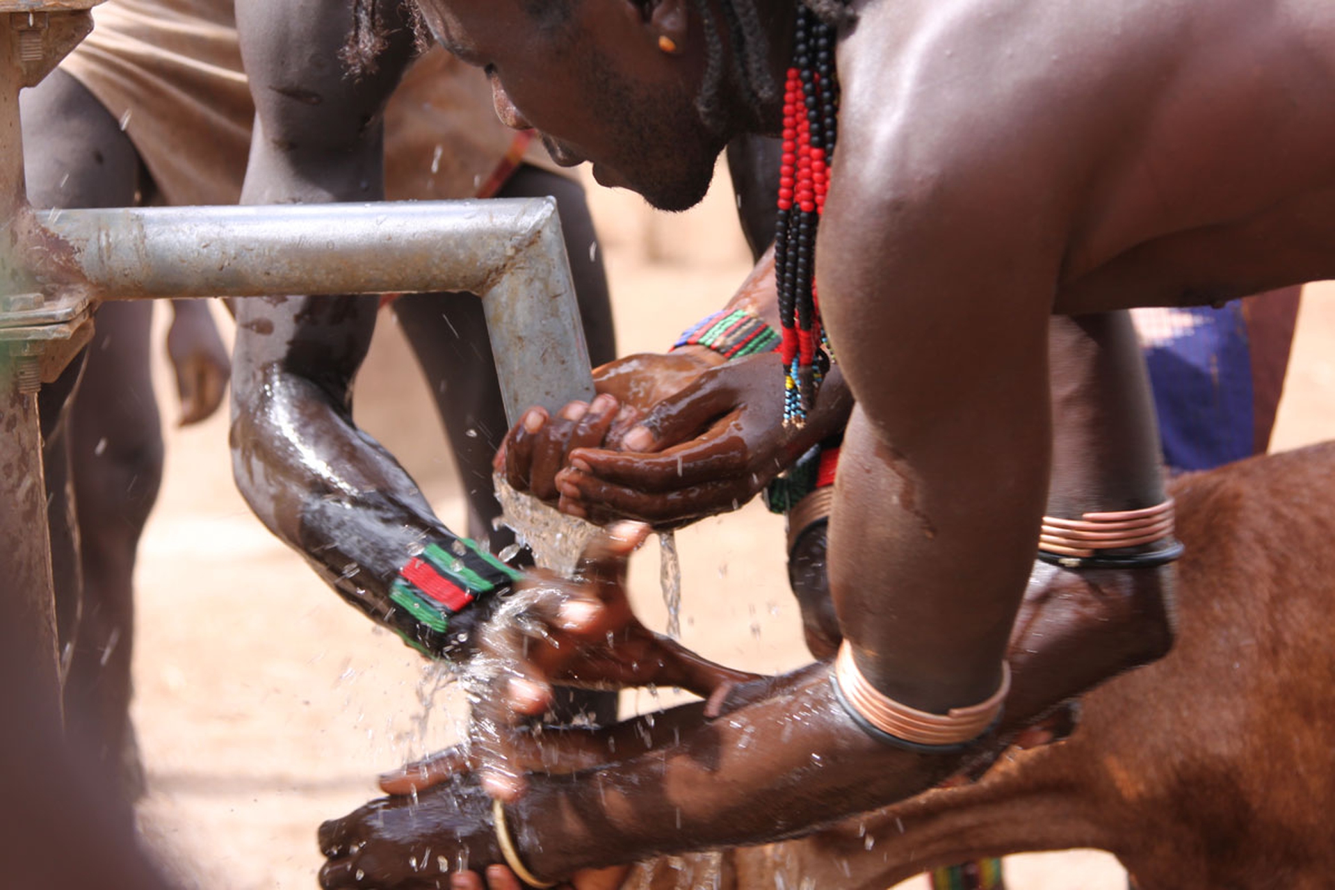 Un ragazzo si lava le mani al pozzo vicino al villaggio Arna
