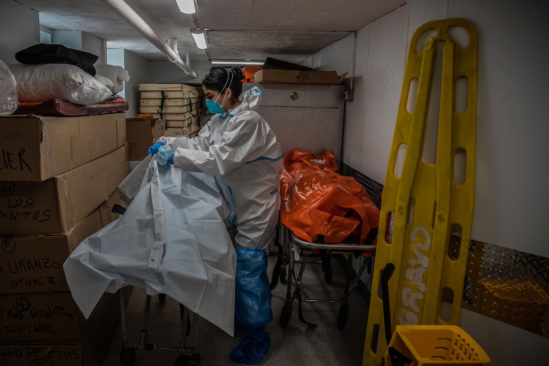 A funeral worker handles coronavirus victims, New York.