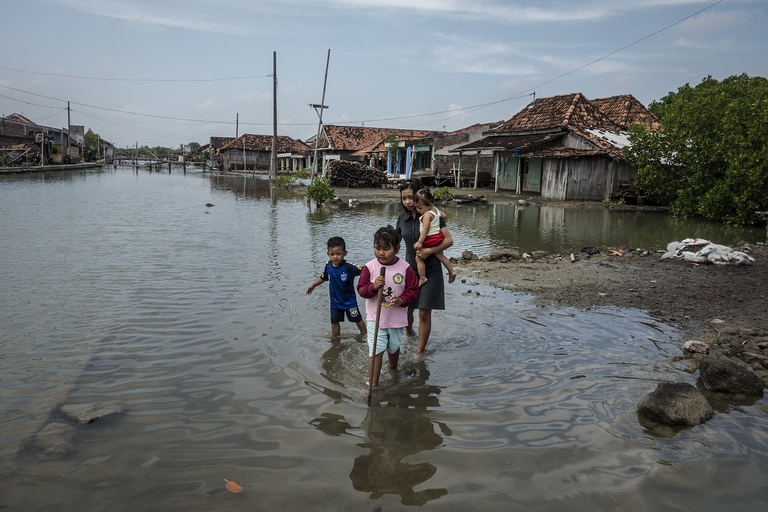 Abitanti di un villaggio in Indonesia lasciano la loro casa allagata