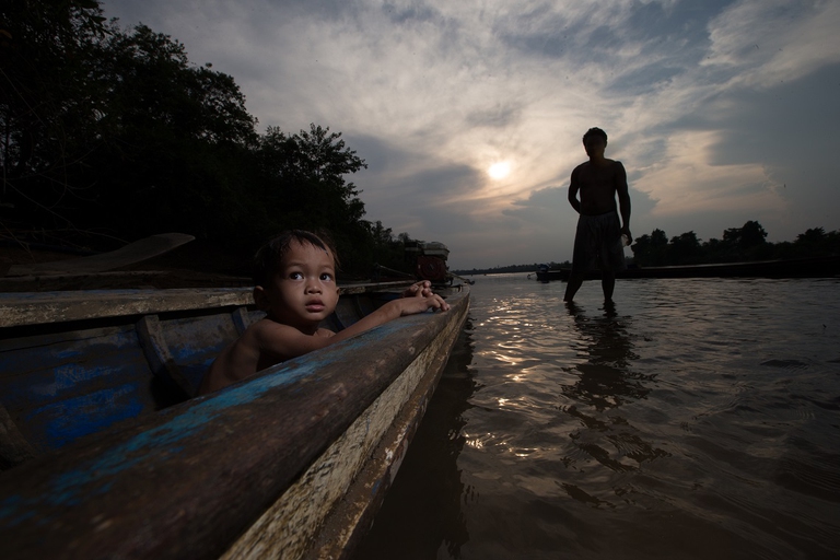 Bambino su una canoa che solca il fiume Mekong
