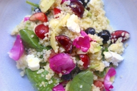 Insalata di bulgur con frutti, fiori, foglie e caprino