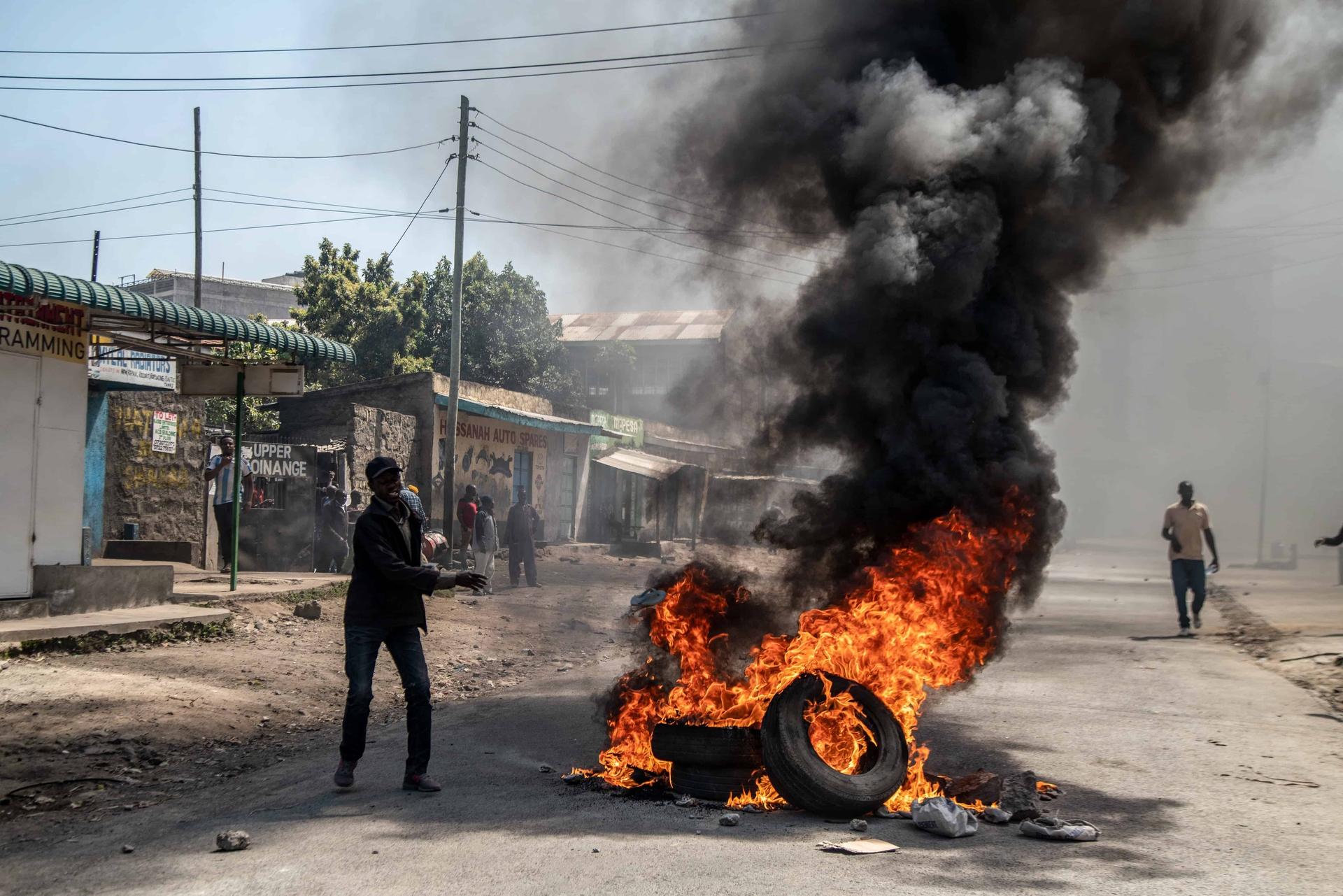 A protester seen with burning tires during the protest