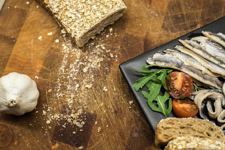 Un piatto con l'occorrente per la ricetta del cavolfiore in insalata e salsa d'acciughe