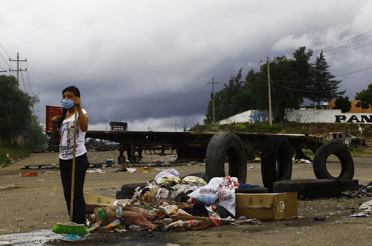 A teacher keeps watch at the entrance of the village of Nochixtlan, Oaxaca State, Mexico on June 21, 2016. Thousands of teachers protested in southern Mexico on Monday to denounce the deaths of eight people after violent weekend clashes that police blamed on unidentified gunmen. /AFP/ Hector Guerrero/Getty Images