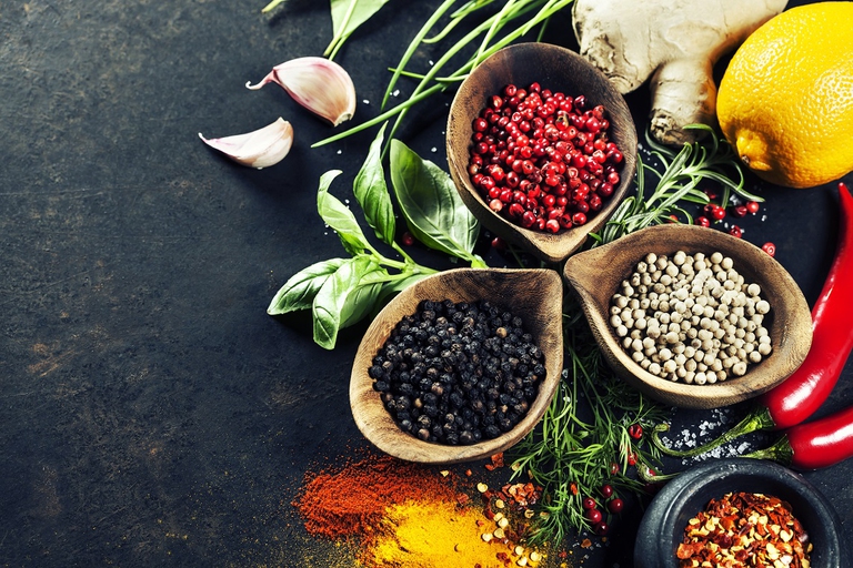 Spezie ed erbe aromatiche in contenitori di legno sopra un tavolo