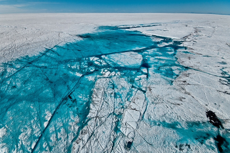 This summer the lake drained slowly as it overflowed through a large melt channel. This deepest region of lake still contained water in early July. The heavily fractured lake bed demonstrates the dramatic nature of the past several lake drainages (see 2009 view http://bigice.apl.washington.edu/photos/Greenland09A-12.jpg).