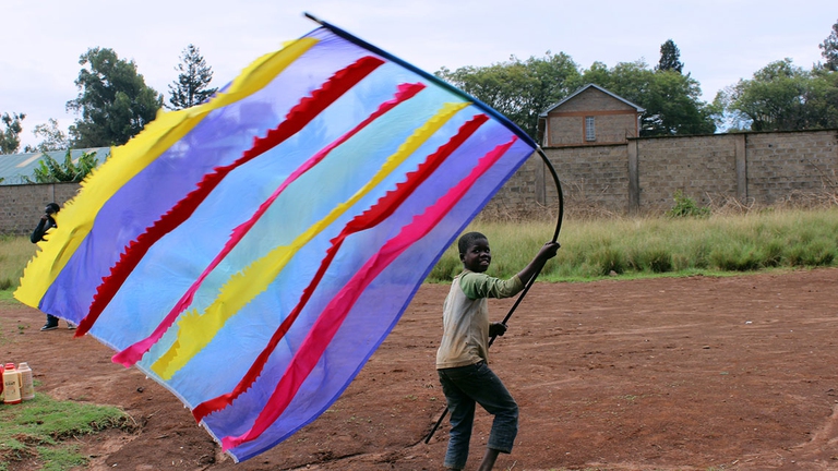 Victor sventola la sua bandiera appena finita al Superpower-tool & Hardeware shop, Kawangware © Cherimus