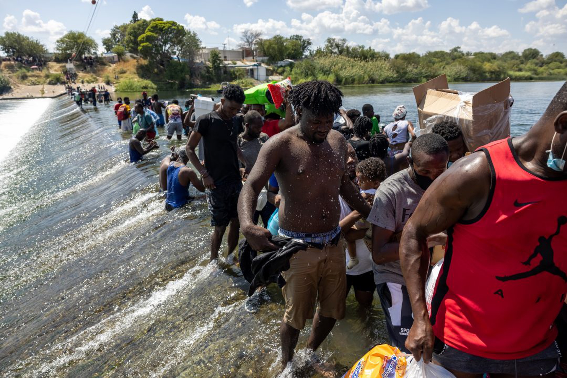 I migranti, perlopiù di Haiti, hanno attraversato il Rio Grande e si trovano in un accampamento di fortuna a Del Rio, in Texas