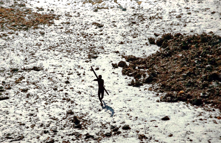 Un membro della popolazione sentinellese che scaglia frecce contro un elicottero