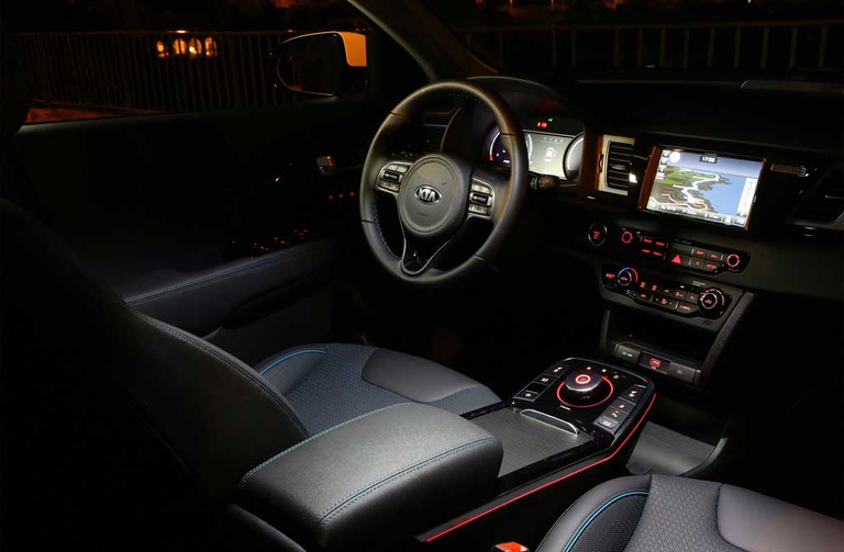 Materiali di qualità e spazio abbondante. L'abitacolo di Kia e-Niro, rispetto ai modelli ibridi propone una nuova consolle fra i sedili anteriori con il comando circolare dal quale gestire le funzioni del motore. Kia e-Niro è la versione elettrica del crossover coreano, già disponibile nei modelli ibrido e ibrido-plug-in. Con 455 chilometri di autonomia e una potenza di 204 cavalli si posiziona nella fascia più attraente del mercato elettrico attuale. © Kia Motors