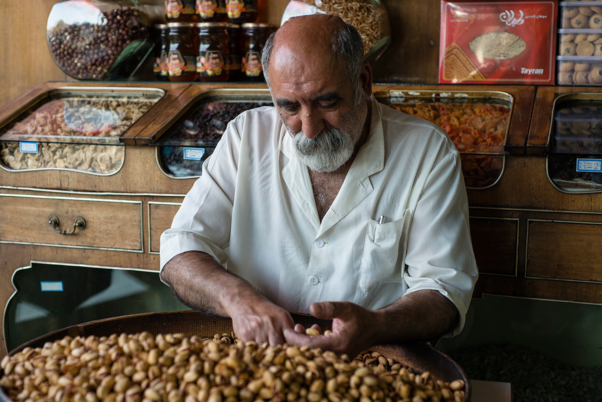Un lavoratore sistema i pistacchi nella sua bottega, a Teheran