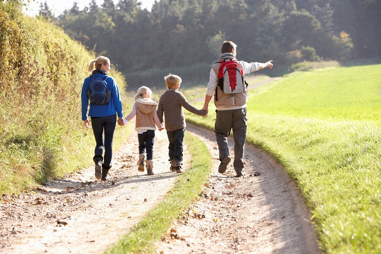 Famiglia che passeggia in una strada sterrata di campagna