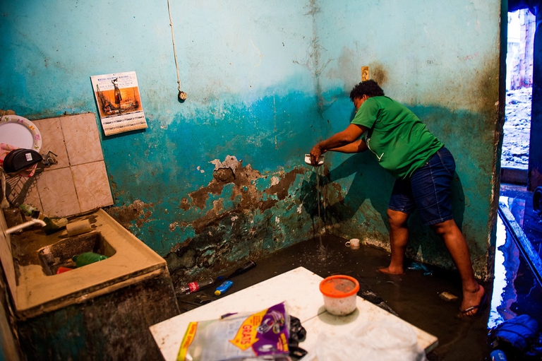 Donna cerca di rimuovere l'acqua in eccesso, all'interno della sua casa