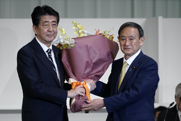 Outgoing prime minister Shinzo Abe with new prime minister Yoshihide Suga