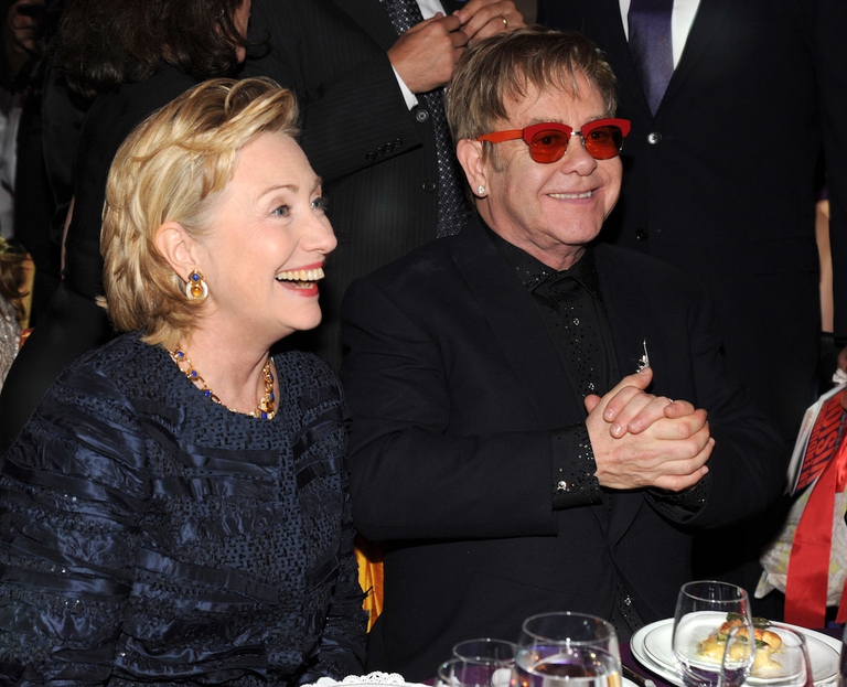 Hilary Clinton e Elton John seduti al tavolo uno accanto all'altro.