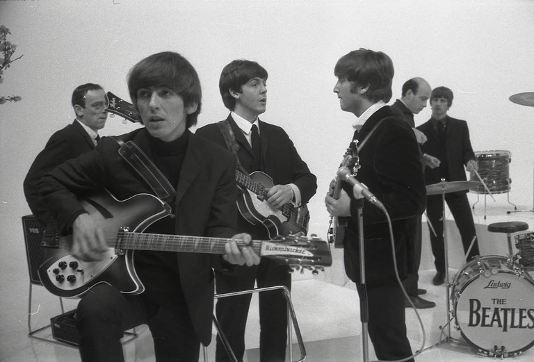 George Harrison suona la sua chitarra Rickenbacker 360/12 insieme a Paul McCartney, John Lennon, Richard Lester (alla direzione), Ringo Starr durante il film 'A Hard Day's Night'.