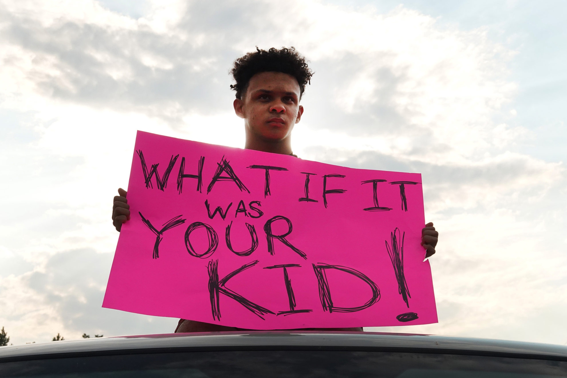 Un ragazzo con un cartello durante le proteste per Jacob Blake