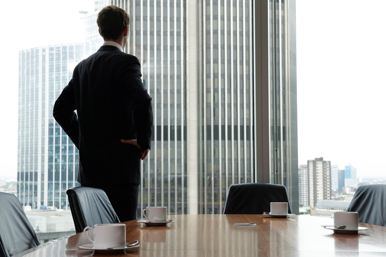 Manager guarda fuori dalla finestra di una sala riunioni vuota