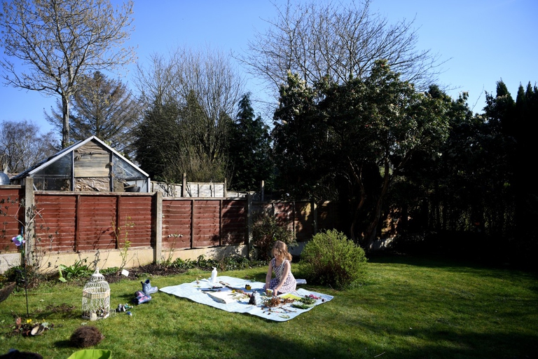 Lois Copley-Jones, 4 anni, mentre svolge attività per la scuola nel suo giardino mentre viene immortalata dal padre fotografo il 25 marzo 2020, il terzo giorno di chiusura nazionale delle scuole. Newcastle Under Lyme, Regno Unito © Gareth Copley/Getty Images