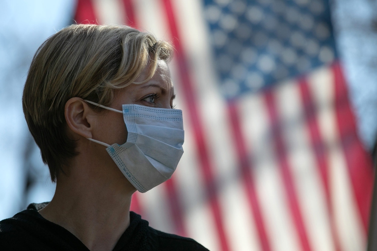 coronavirus stati uniti donna bionda di fronte a bandiera americana