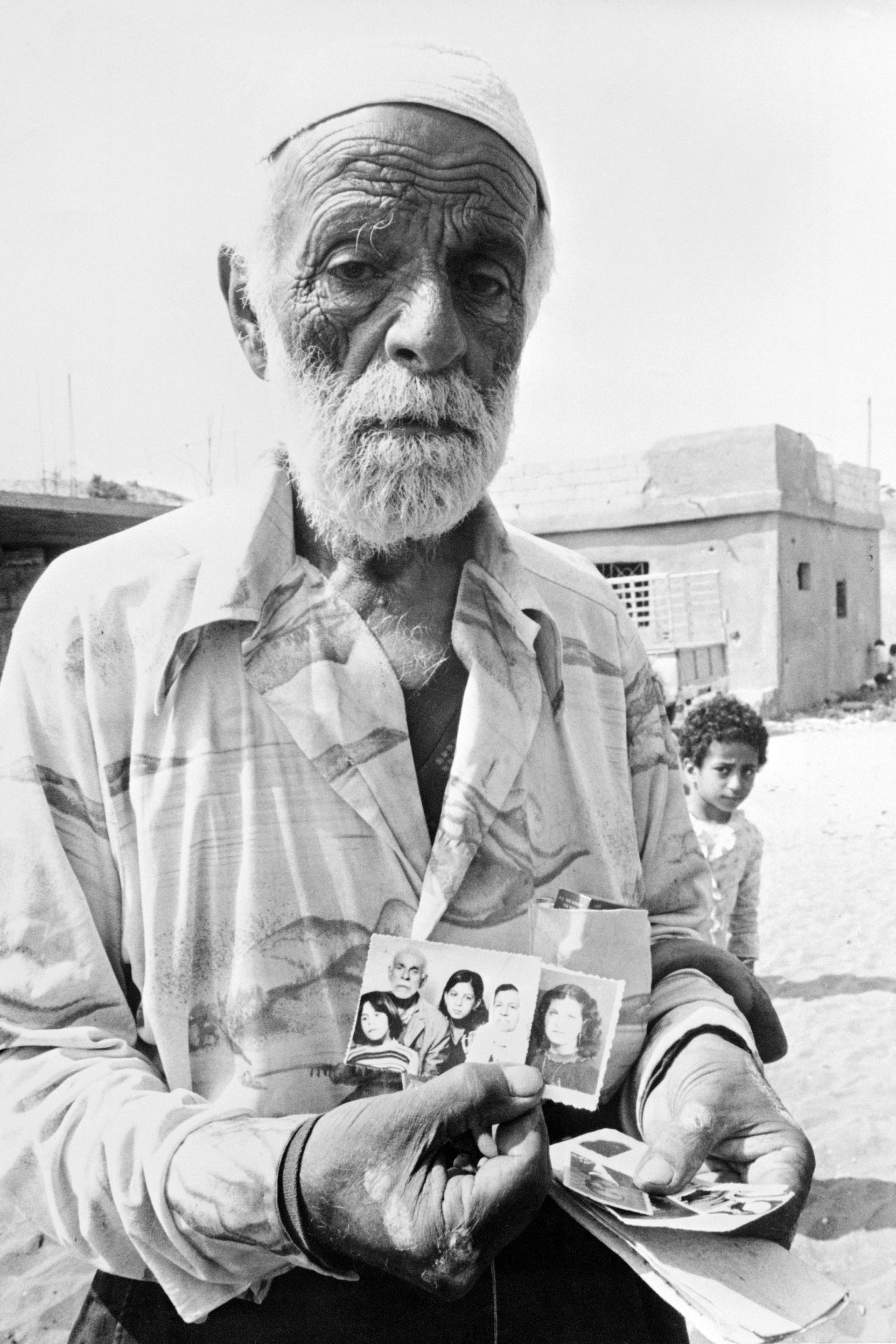 Un rifugiato palestinese mostra le foto dei cari trucidati nel campo profughi di Shatila