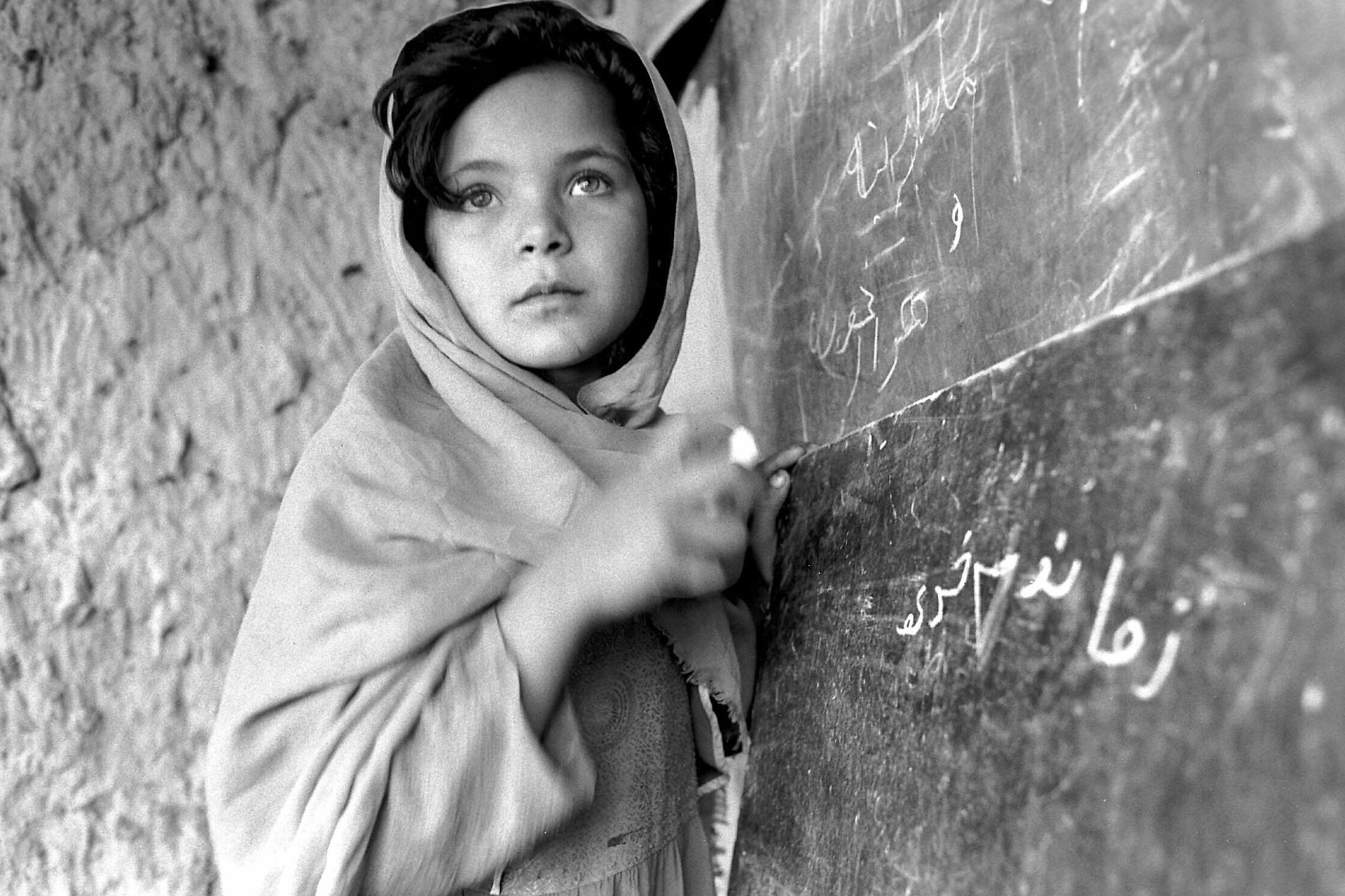 Una bambina afghana studia in una scuola dell'Onu