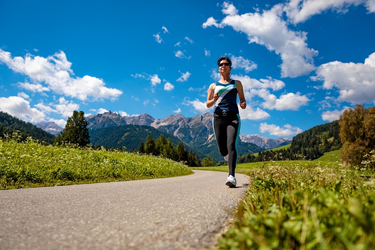 Donna che corre ai piedi delle Dolomiti