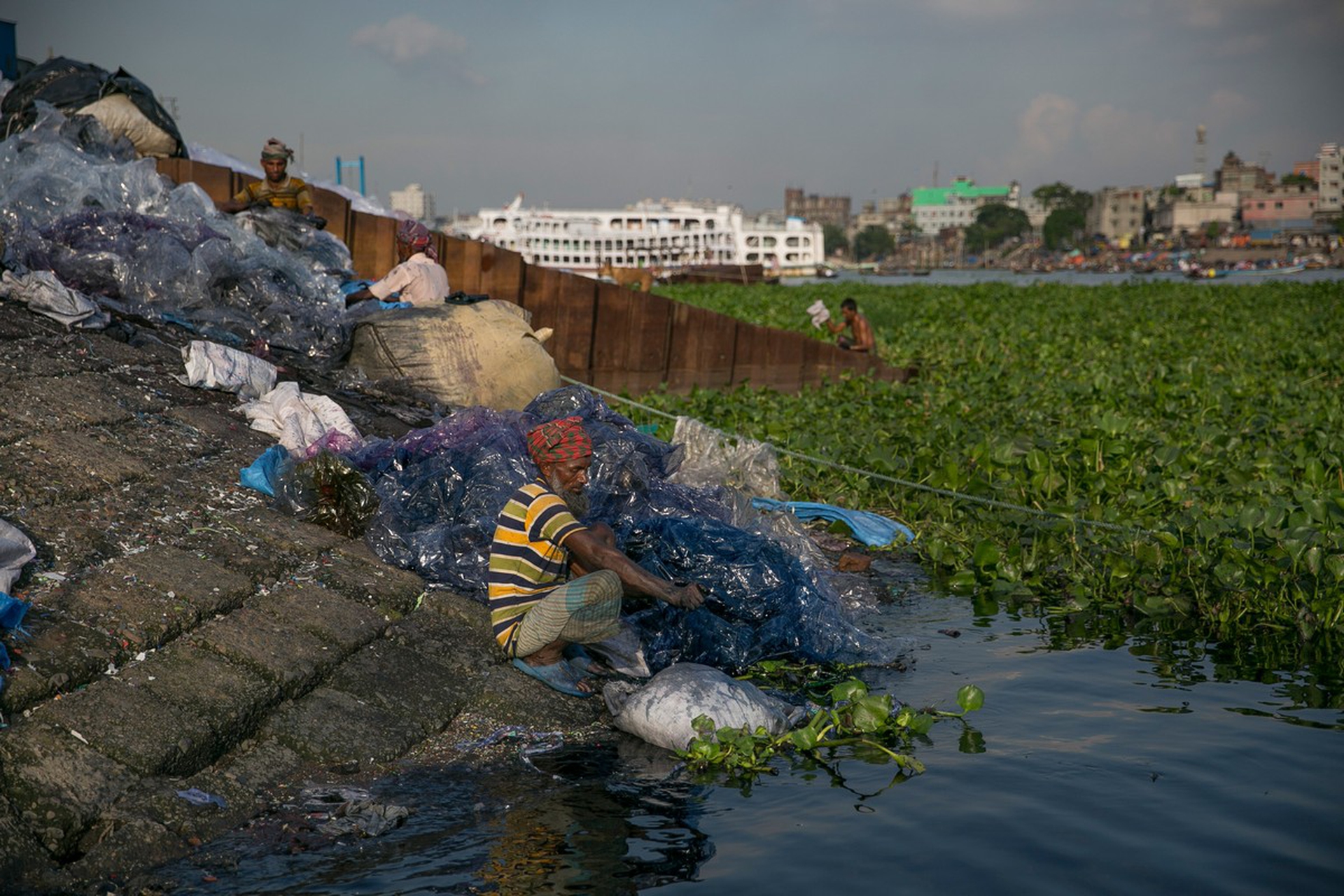 Le sponde di un fiume iquinato con rifiuti di plastica in Bangladesh
