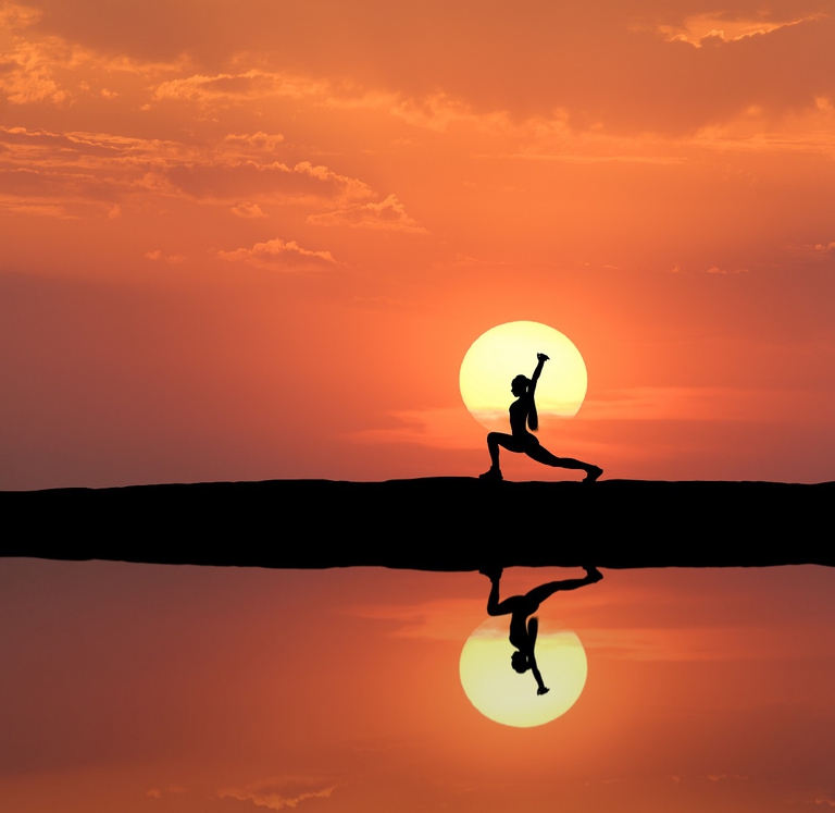 Donna pratica la meditazione trascendentale in concomitanza con il tramonto del sole
