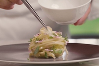 Spaghetti tiepidi con porri alla brace, margherite e portulaca. Ricetta estiva