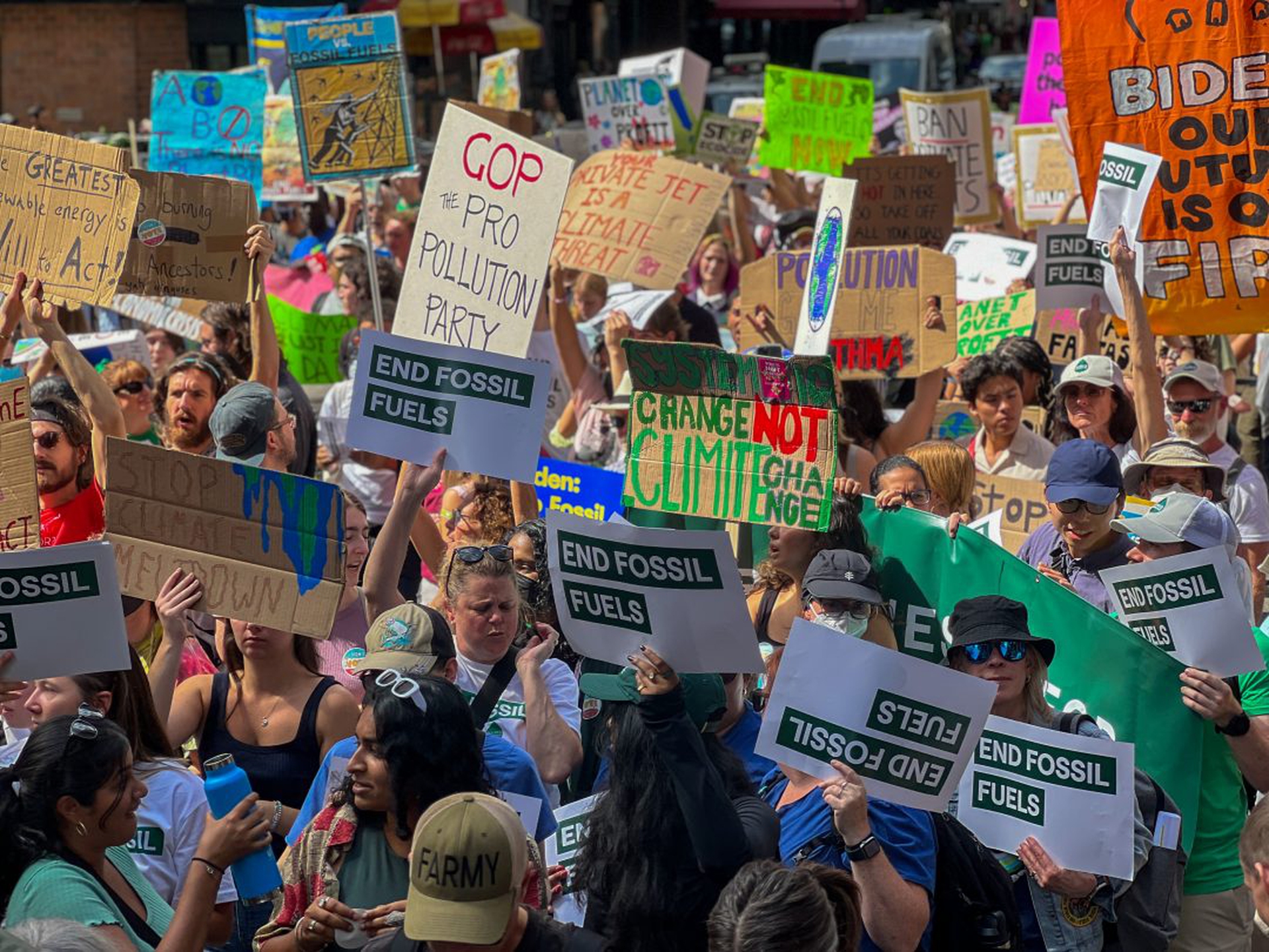 Protesters hold placards against fossil fuel expansion.