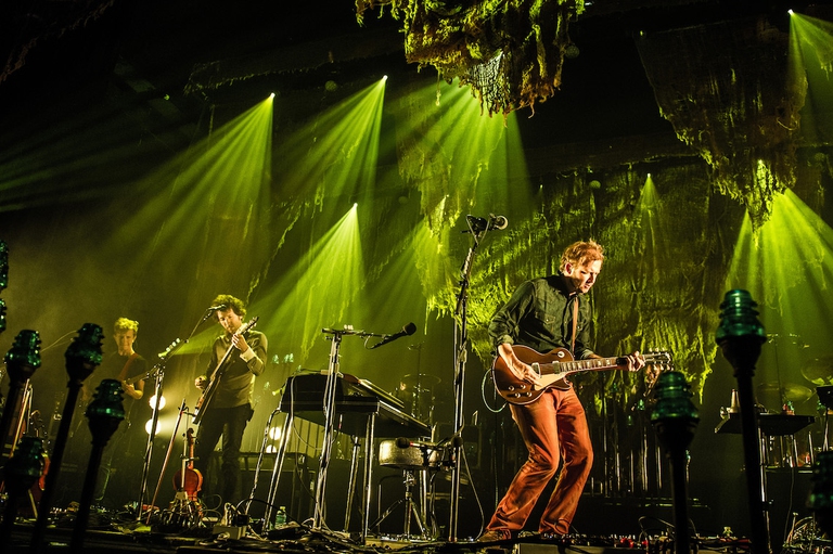 Rob Moose e Justin Vernon di Bon Iver suonano sul palco, illuminati dalle luci verdi, dell'Olympia di Parigi nel luglio 2012.