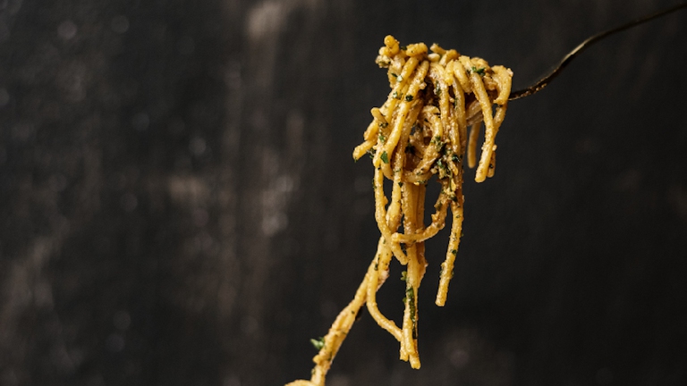 Una forchettata di spaghetti con funghi shiitake secchi e noci.