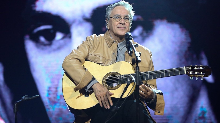 Caetano Veloso sul palco imbraccia la chitarra.