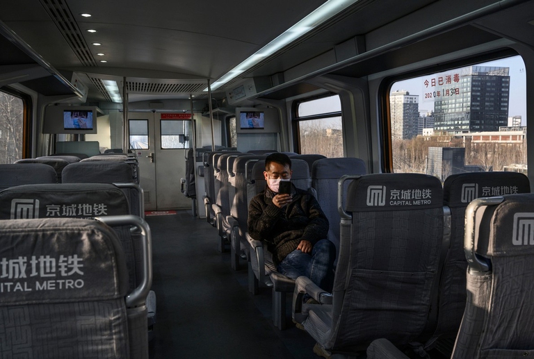 Un uomo siede da solo su un autobus in Cina durante l'epidemia del nuovo coronavirus
