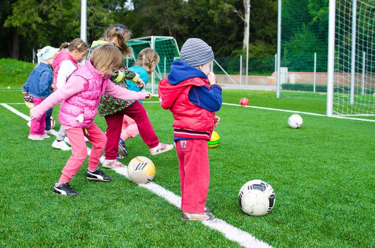 Bambini su un campo di calcio giocano con la palla 
