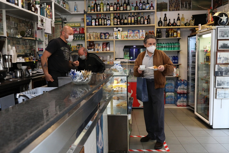 Un uomo prende un cappuccino in sicurezza dopo il lockdown