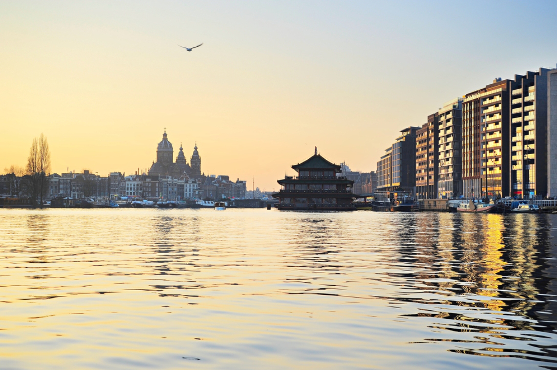 Sunset view of Amsterdam with reflection in the river Holland