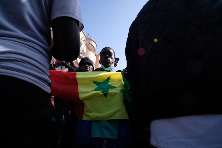 Senegal, un manifestante tiene in mano la bandiera del Paese