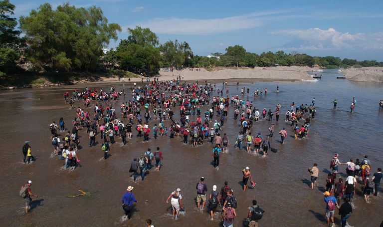 La carovana di migranti prova ad attraversare il fiume al confine tra Guatemala e Messico