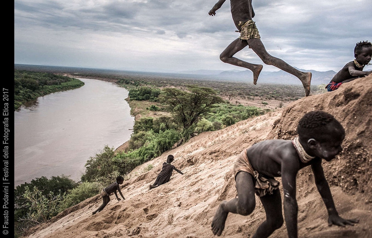 Alcuni bambini giocano saltando nella sabbia vicino al villaggio dei Karo, situato in un’ansa naturale del fiume Omo