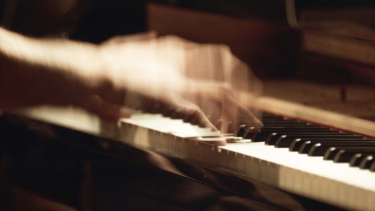 Le mani di Nils Frahm si poggiano con vigore sui tasti del piano