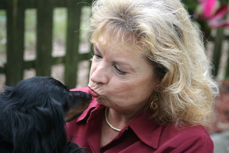 Una donna che bacia un cane