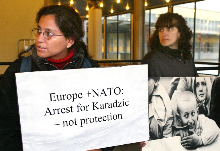 A protester holds up a photo of victims of the war in Bosnia (Photo by Michel Porro/Getty Images) - Generated by  IJG JPEG Library