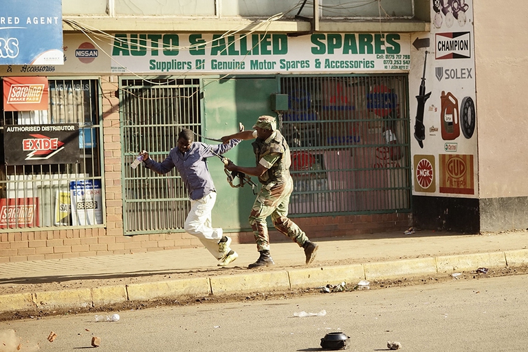 Un soldato colpisce un manifestante per le strade della capitale Harare. Gli oppositori del partito di maggioranza contestano il risultato delle elezioni, ritenendolo falsato © Zinyange Auntony/AFP/Getty Images