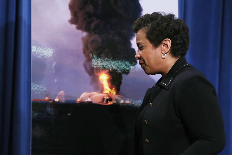 Loretta Lynch e un'immagine della piattaforma Deepwater horizon in fiamme