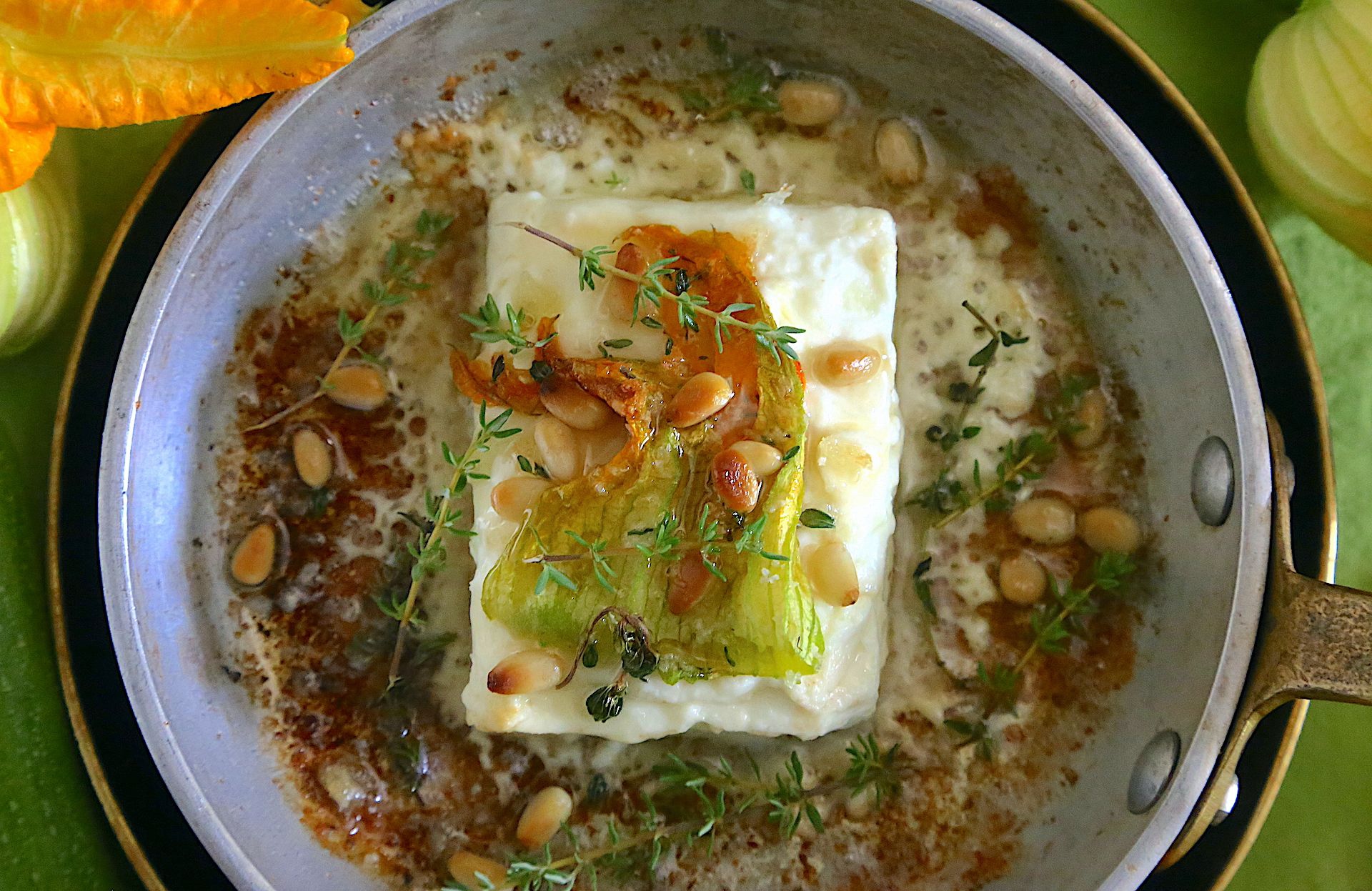 Feta arrostita con fiori di zucchina, miele e pinoli. La ricetta